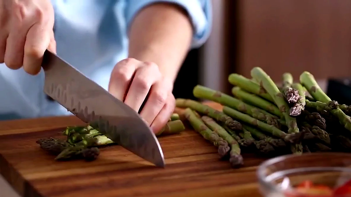 Asparagus being cut into bite size pieces