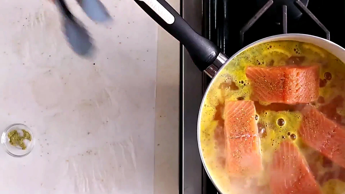 Salmon fillets poaching in the pan