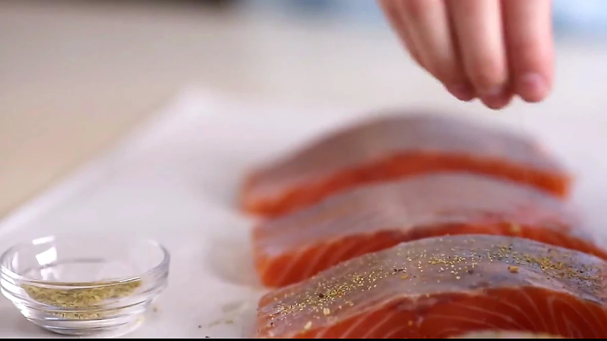 Seasoned salmon fillets on parchment