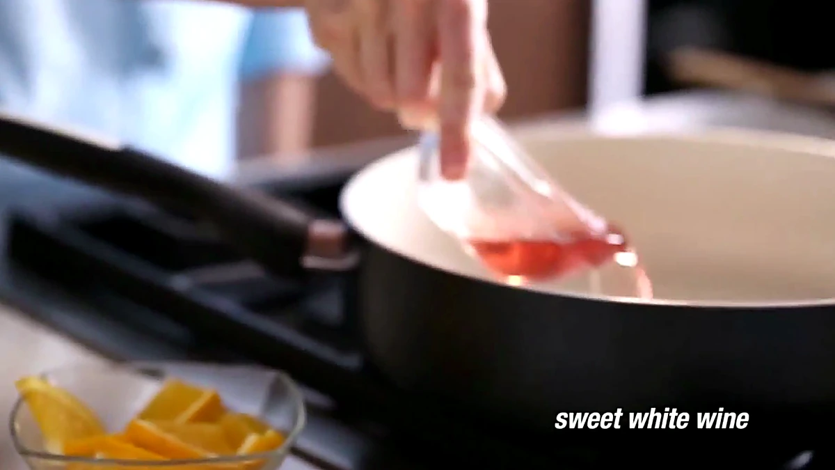 Sweet white wine poured into a saute pan