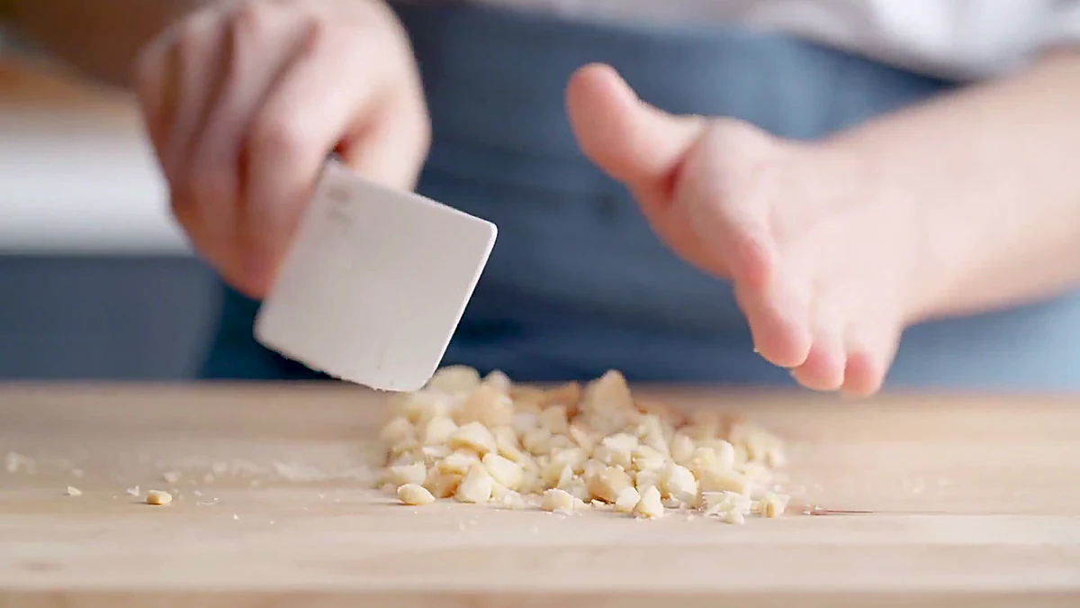 Cashews being chopped on a cutting board
