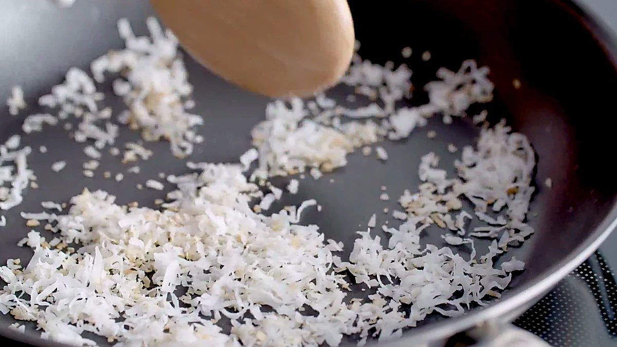 Shredded coconut toasting in a skillet