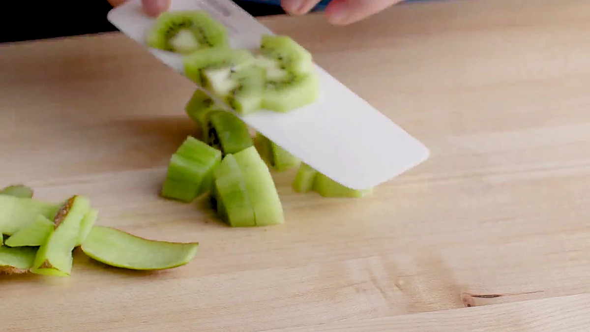 Kiwi being chopped for tropical shrimp salad
