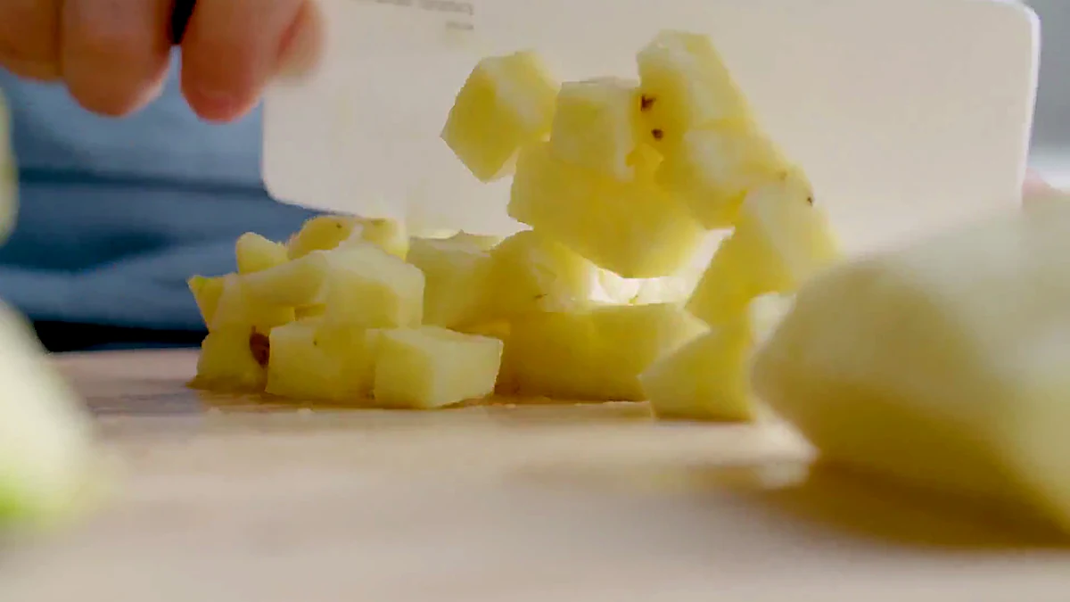 Pineapple chunks being cut