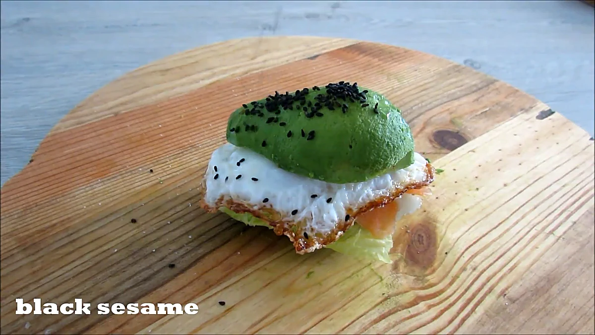Black sesame seeds sprinkled over avocado burger