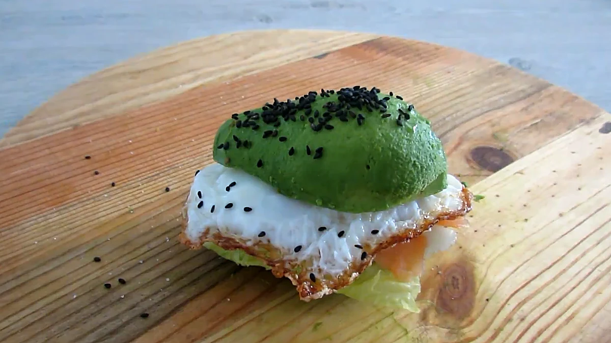Finished avocado burger on a wooden board