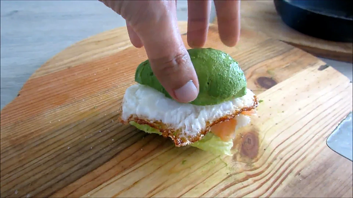 Top avocado half added to the burger
