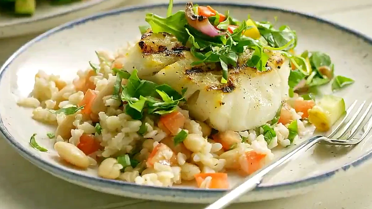 Overhead plate of basil pepper fish with rice and relish