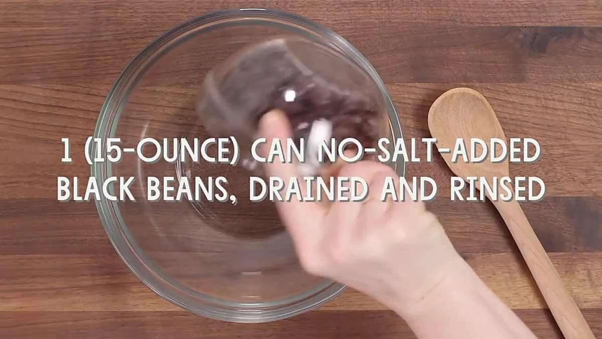 Black beans added to a glass bowl