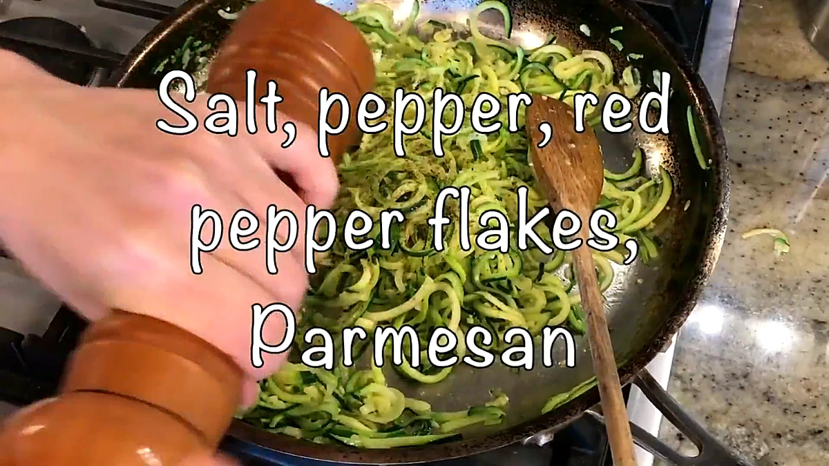 Salt pepper and red pepper flakes added to zucchini noodles
