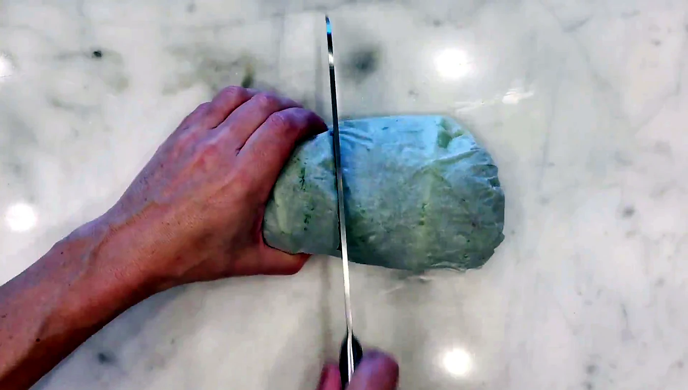 Knife slicing the wrapped lettuce sandwich