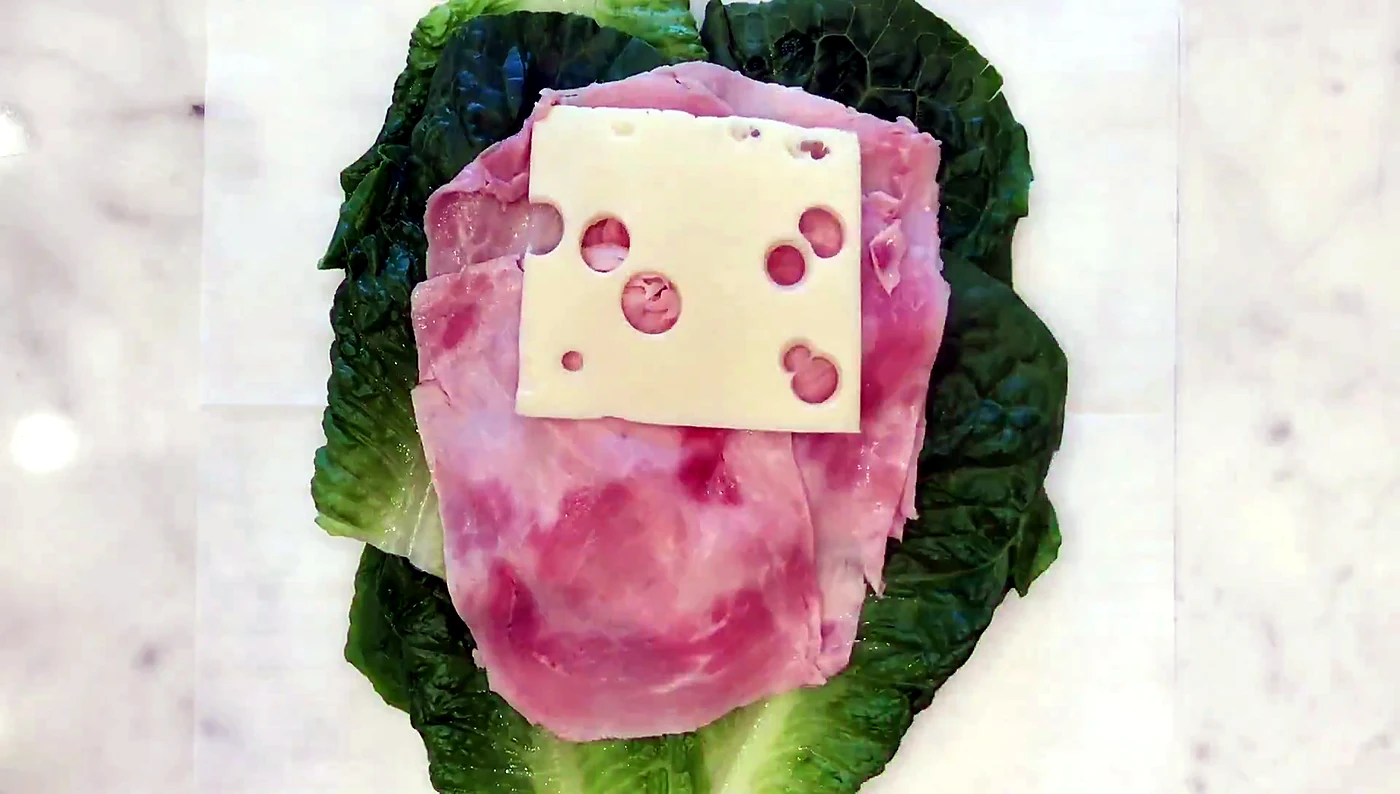 Swiss cheese added to a lettuce sandwich wrap