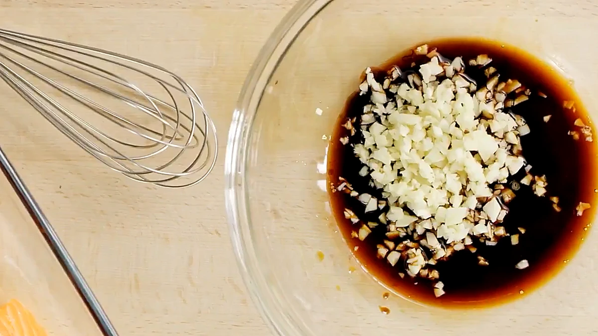 Citrus balsamic marinade with ginger and garlic stirred together in a glass bowl