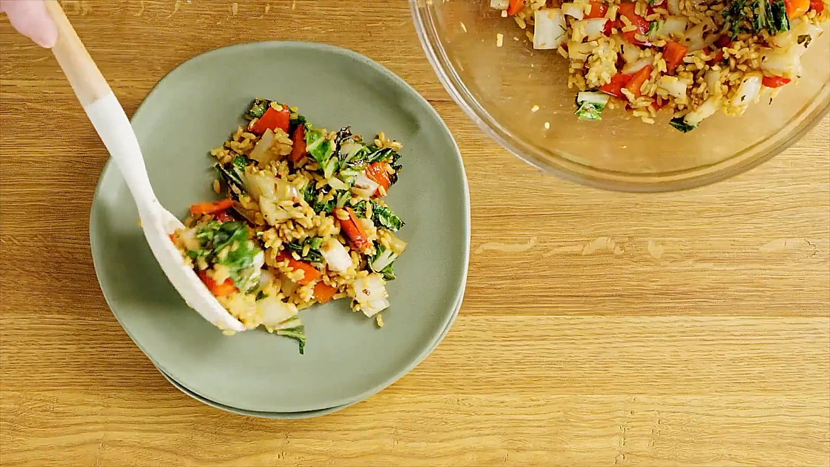 Warm bok choy rice salad spooned onto a green plate