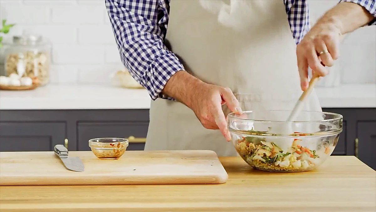 Brown rice tossed with grilled bok choy, red pepper, and herbs in a glass bowl