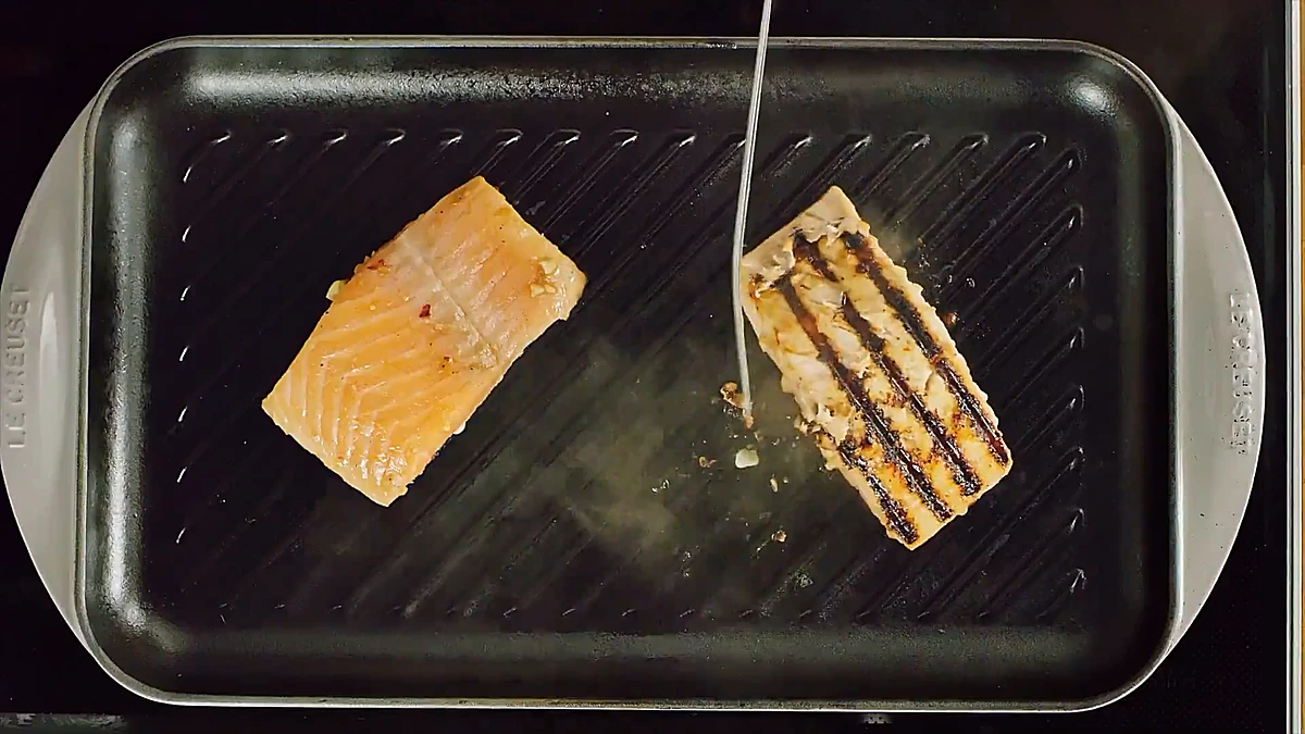 Salmon fillets cooking on a grill pan with grill marks
