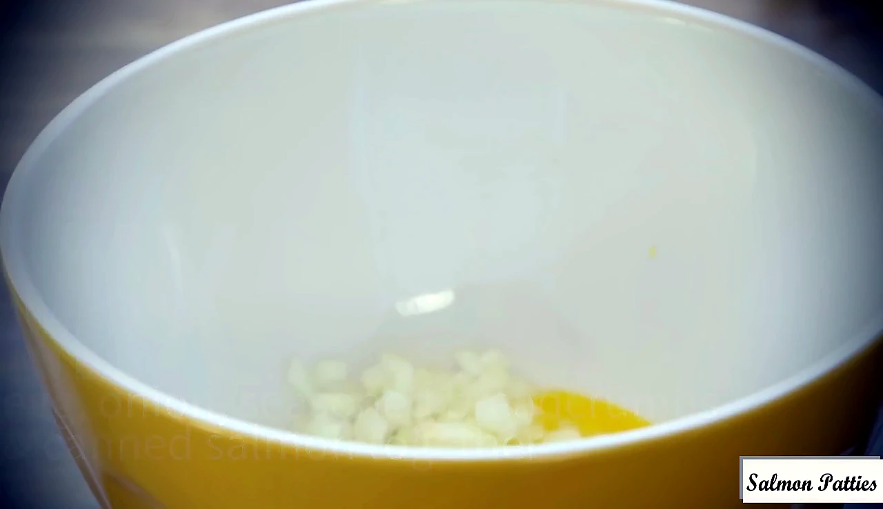 Chopped onion added to egg in a bowl