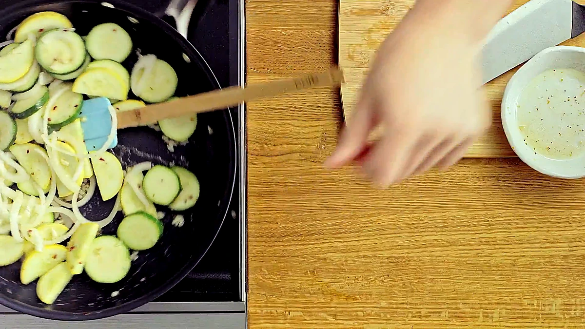 Zucchini, yellow squash, and onion cooking in a skillet