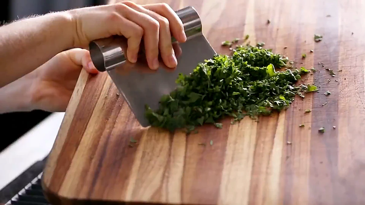 Fresh parsley being chopped on a wooden board