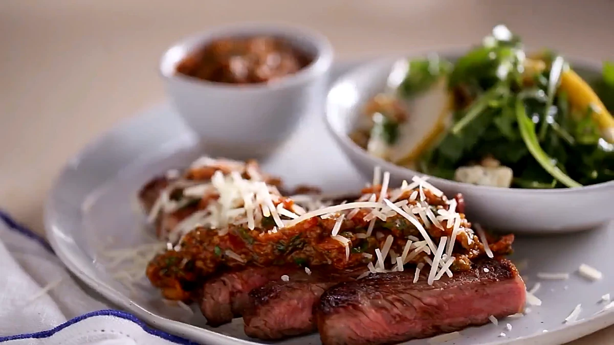 Steak with mushroom marinara and parmesan served with pear arugula salad