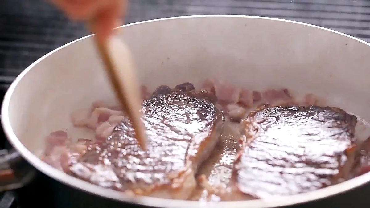 Two steaks searing in a hot skillet