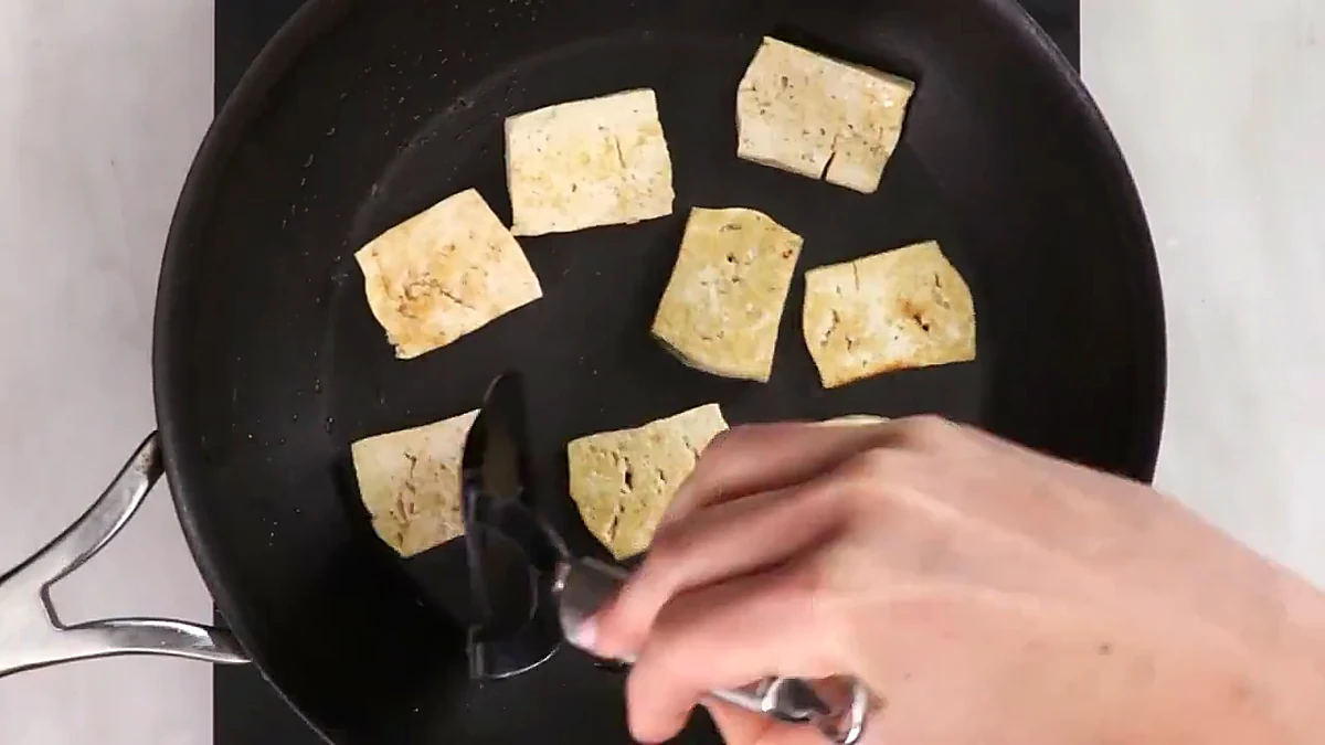 Tofu pieces flipped while cooking