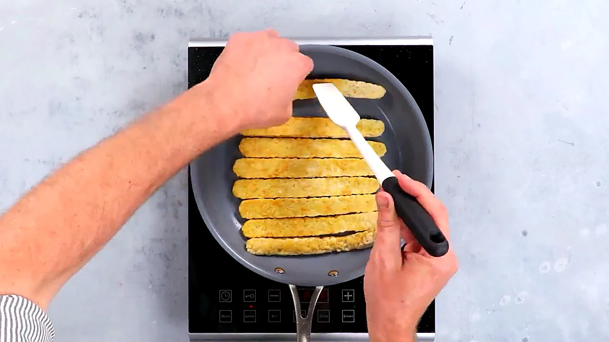 Tempeh strips flipped in skillet