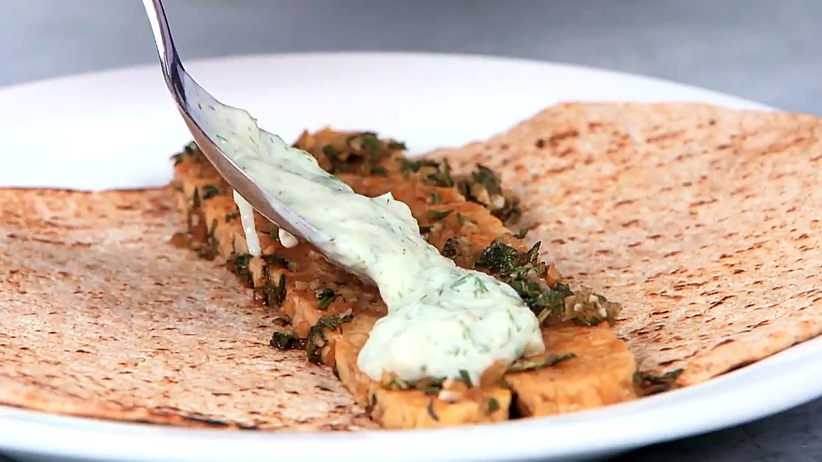 Tzatziki sauce spooned over tempeh