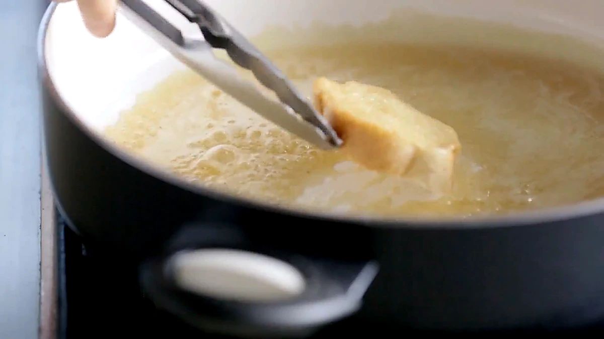 A bread slice toasting in the butter and maple syrup