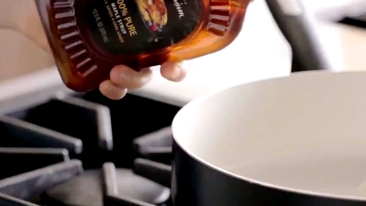 Maple syrup being poured into a pan with melting butter