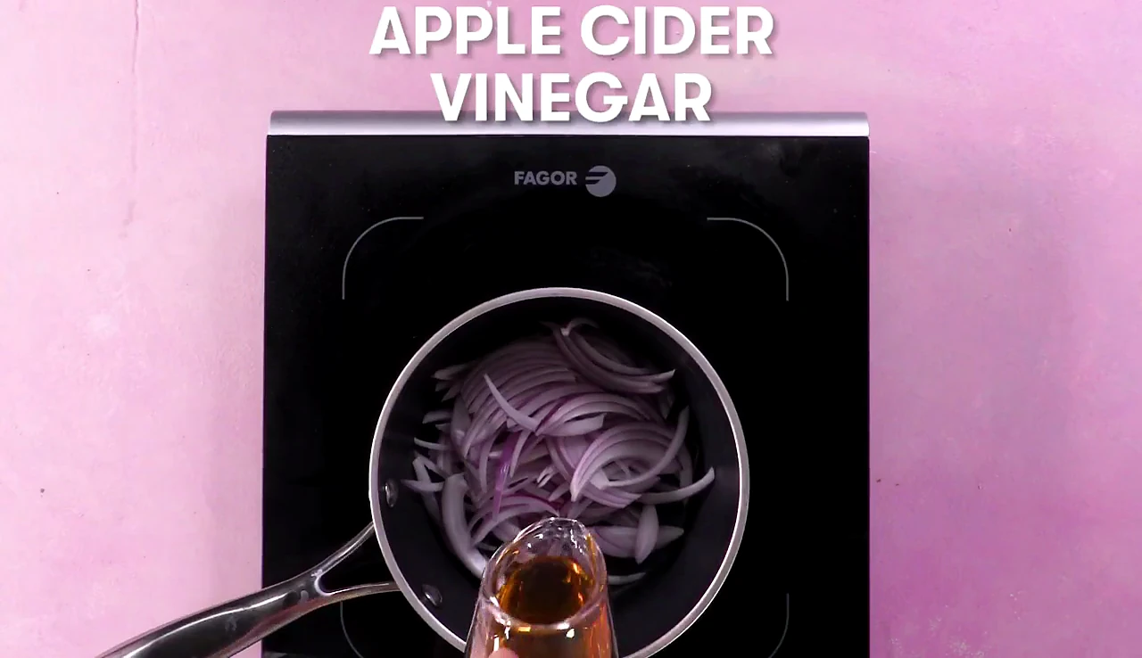 Apple cider vinegar poured over red onions