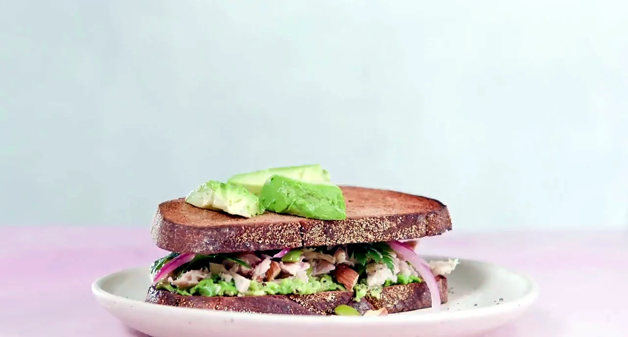 Stacked tuna avocado sandwich on a plate