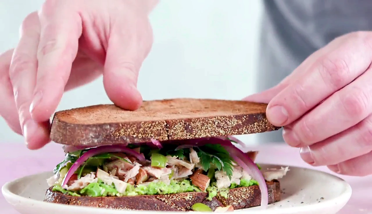 Top bread set over tuna avocado sandwich