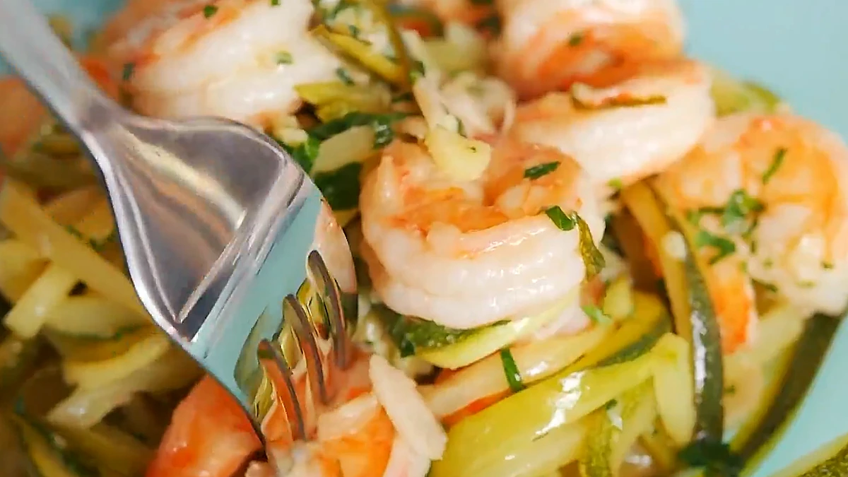 Fork lifting zucchini noodles with shrimp